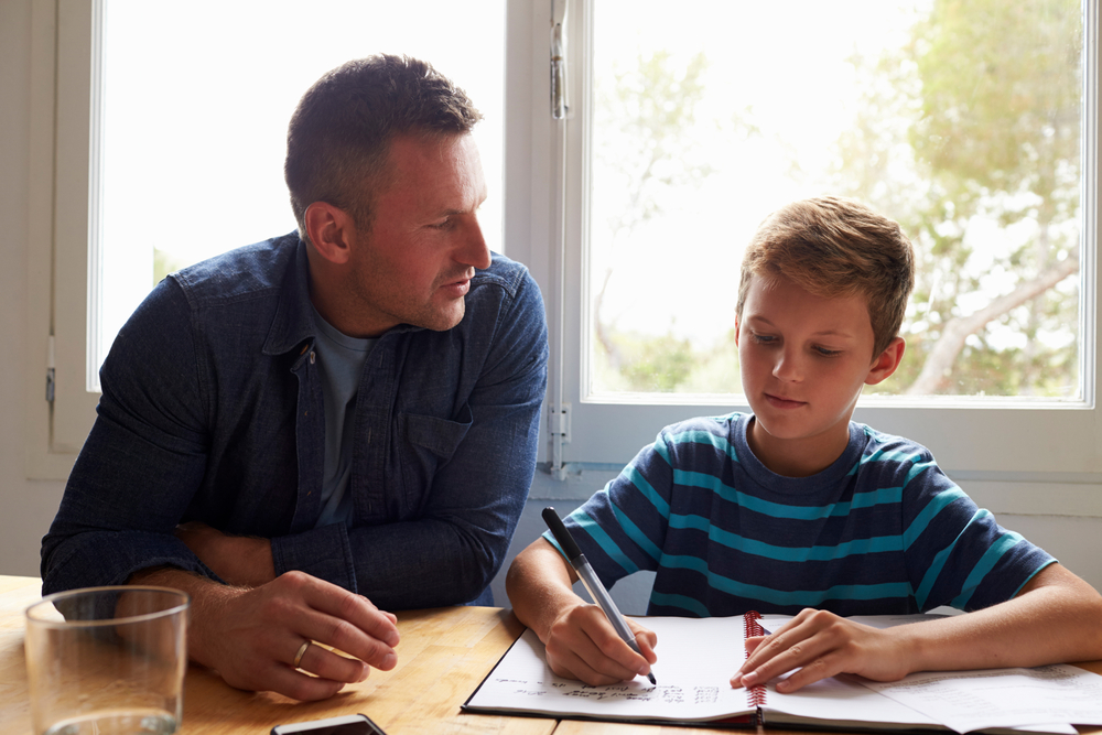 A father helps his son with homework.